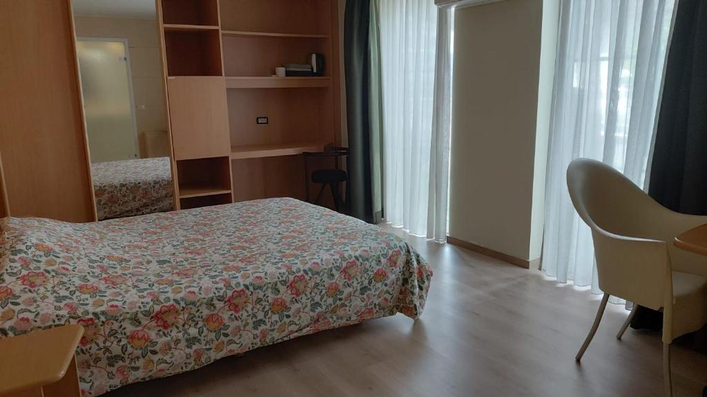 a bedroom with a bed and a desk and a mirror at Kamerverhuur Bascule in Roeselare