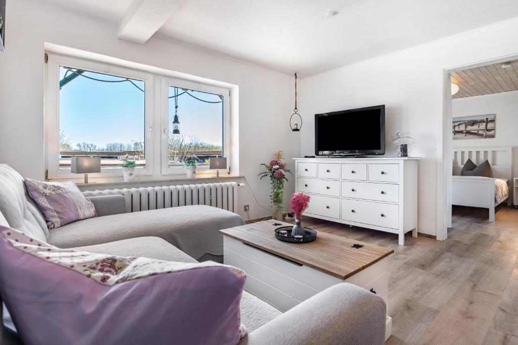 a living room with two couches and a tv at Ferienwohnung Wulf in Groß Zicker