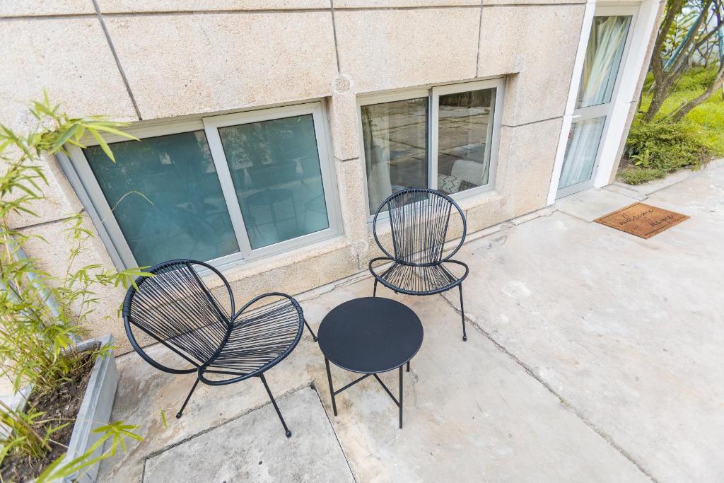 two chairs and a table in front of a building at Appartement T2 atypique de standing in Pointe-Noire