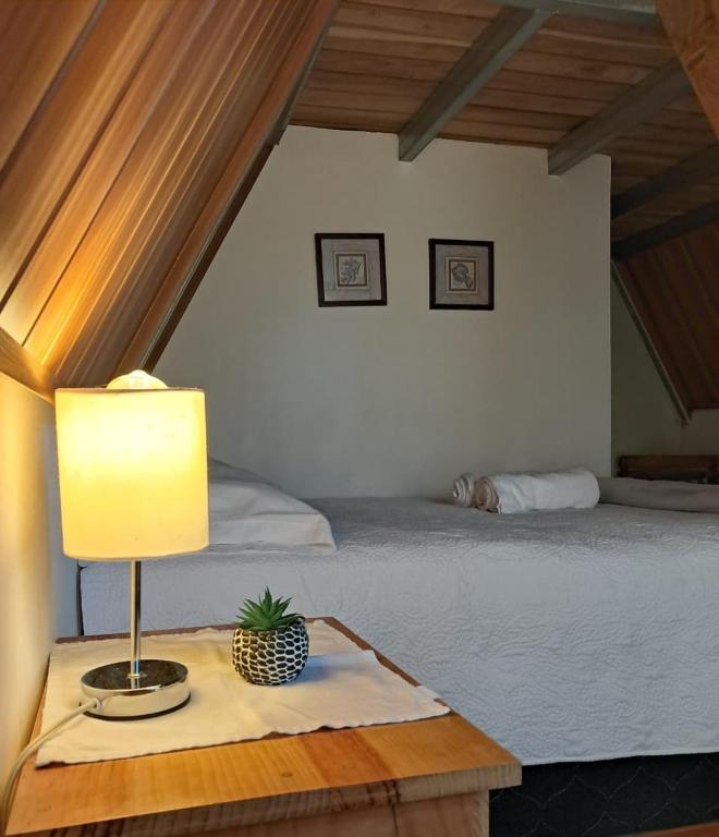 a lamp on a table next to a bed at #1 Jardín de las cabanas in San Pedro Carchá