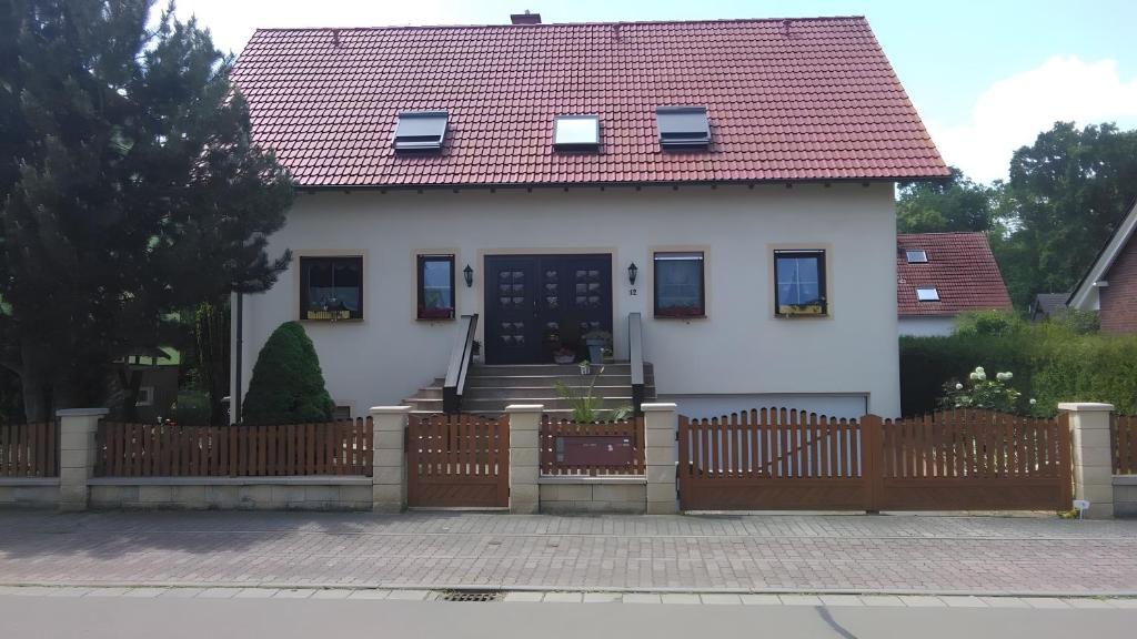 a white house with a wooden fence at Haus Göhrenz in Markranstädt