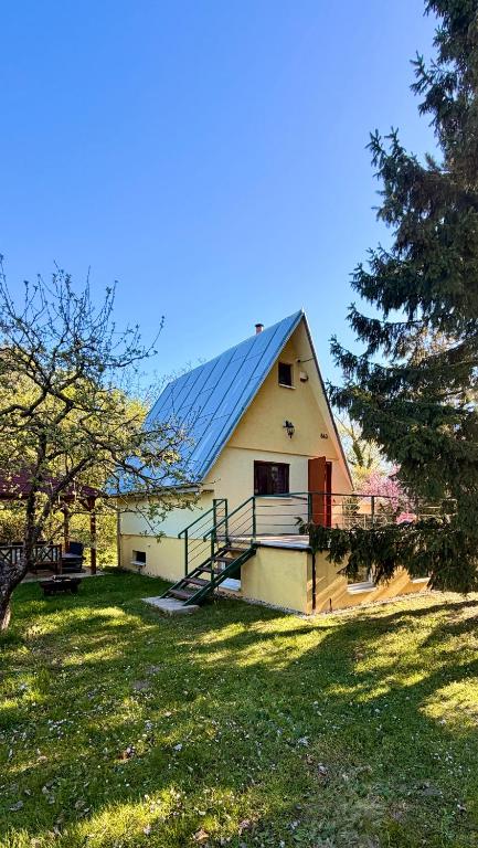 a house with a solar roof on a grass field at Chata Sekule in Sekule