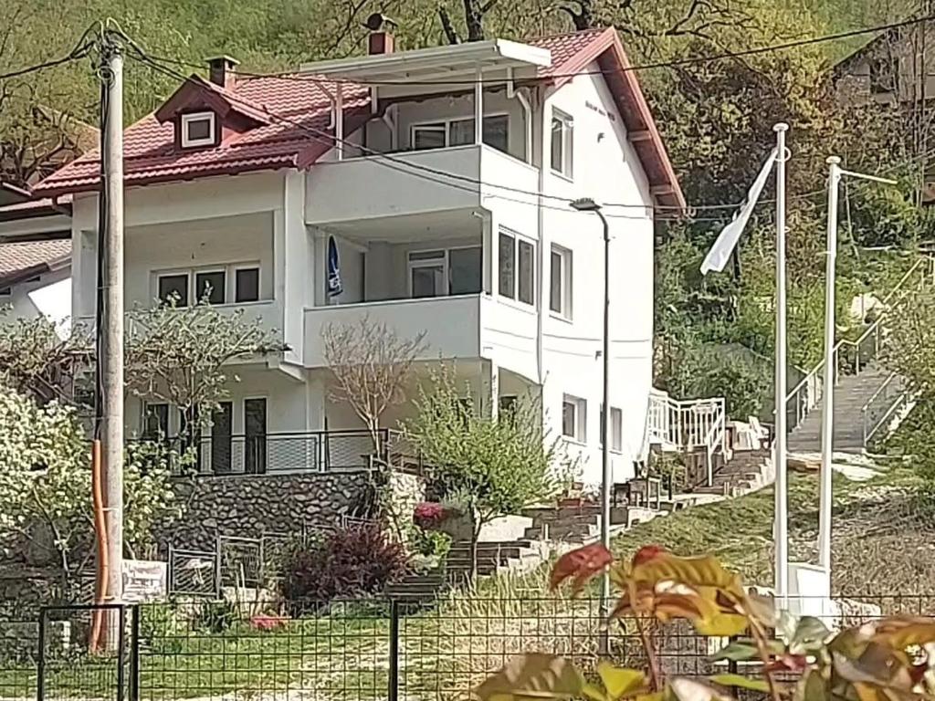 a white house with a fence in front of it at Boračko Lake View Apartment "doelend" in Konjic