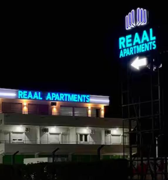 a building with a neon sign on top of it at Reaal Apartaments 1 in Mazgit