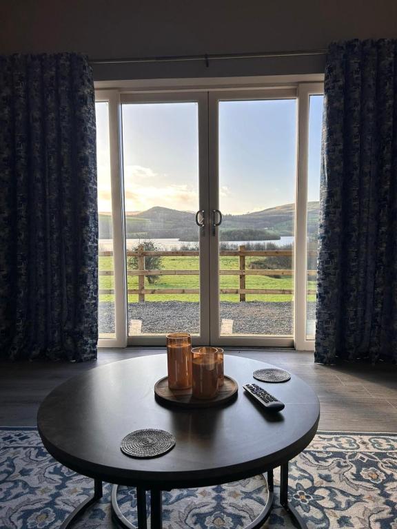 a coffee table in front of a large window at Lakeside cottage retreat in Belcoo
