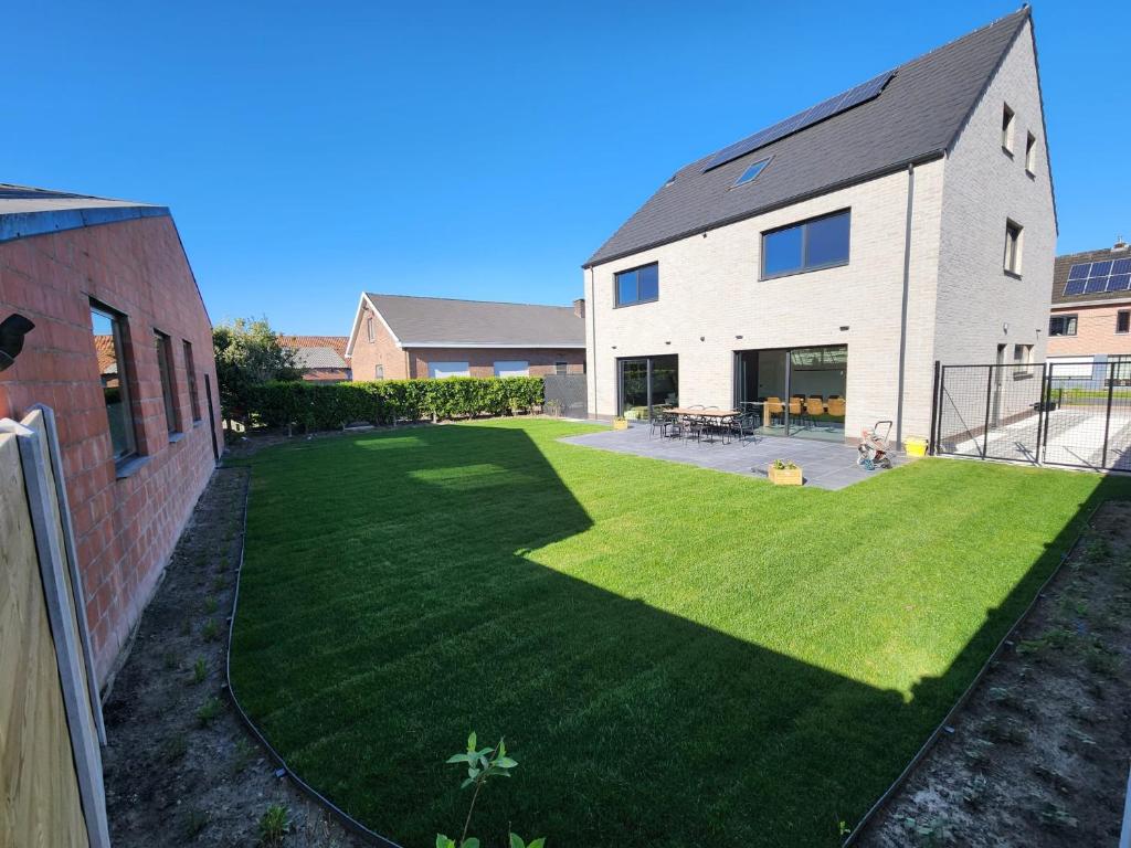 an open yard with a house with a lawn at 't Ossenhoekske in Sint-Niklaas