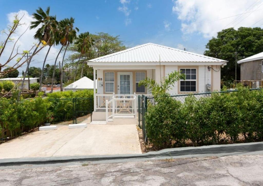 a small white house with a gate at The White Villa in Saint James