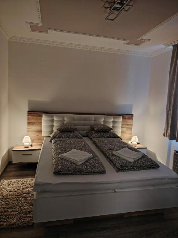 a bedroom with a large white bed with two pillows at JÁZMIN magán szállás in Makó