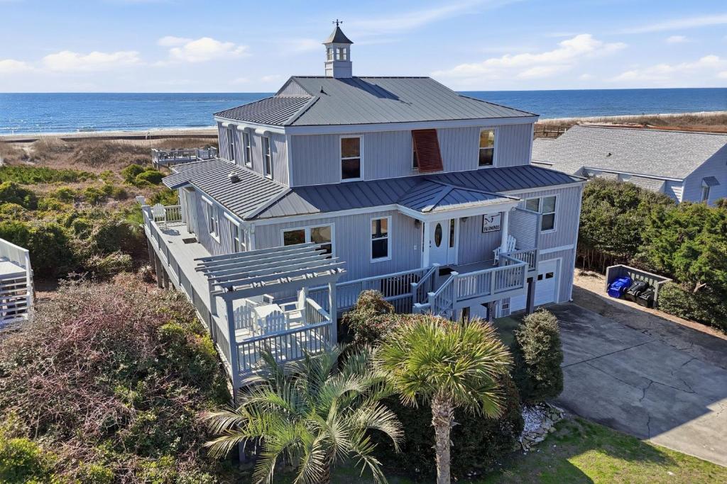 an aerial view of a white house with a lighthouse at Fairwinds by Oak Island Accommodations in Caswell Beach