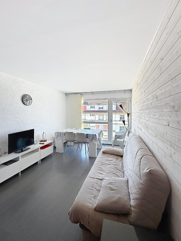 a living room with a couch and a dining room at Pies de Mer in Fort-Mahon-Plage