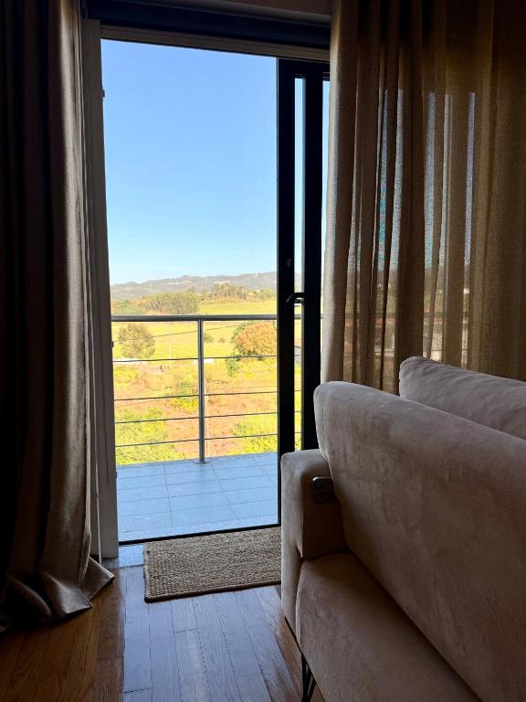 a living room with a couch in front of a sliding glass door at Horizonte da Vinha in Santo Tirso