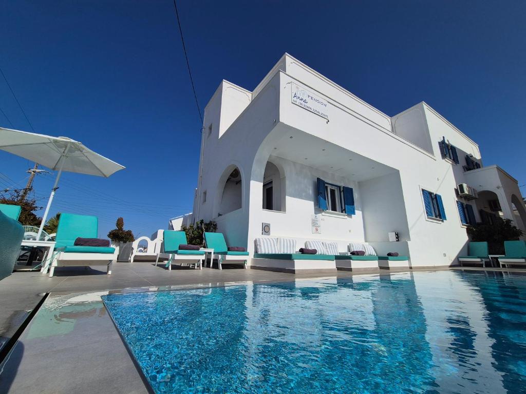a villa with a swimming pool and blue chairs at Anna's in Karterados