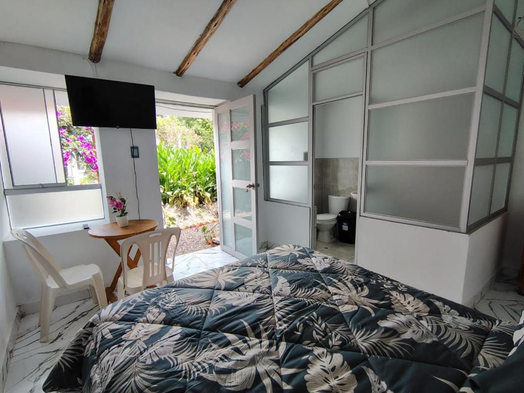 a bedroom with a bed and a television and a table at Casa Jardin in Ayacucho