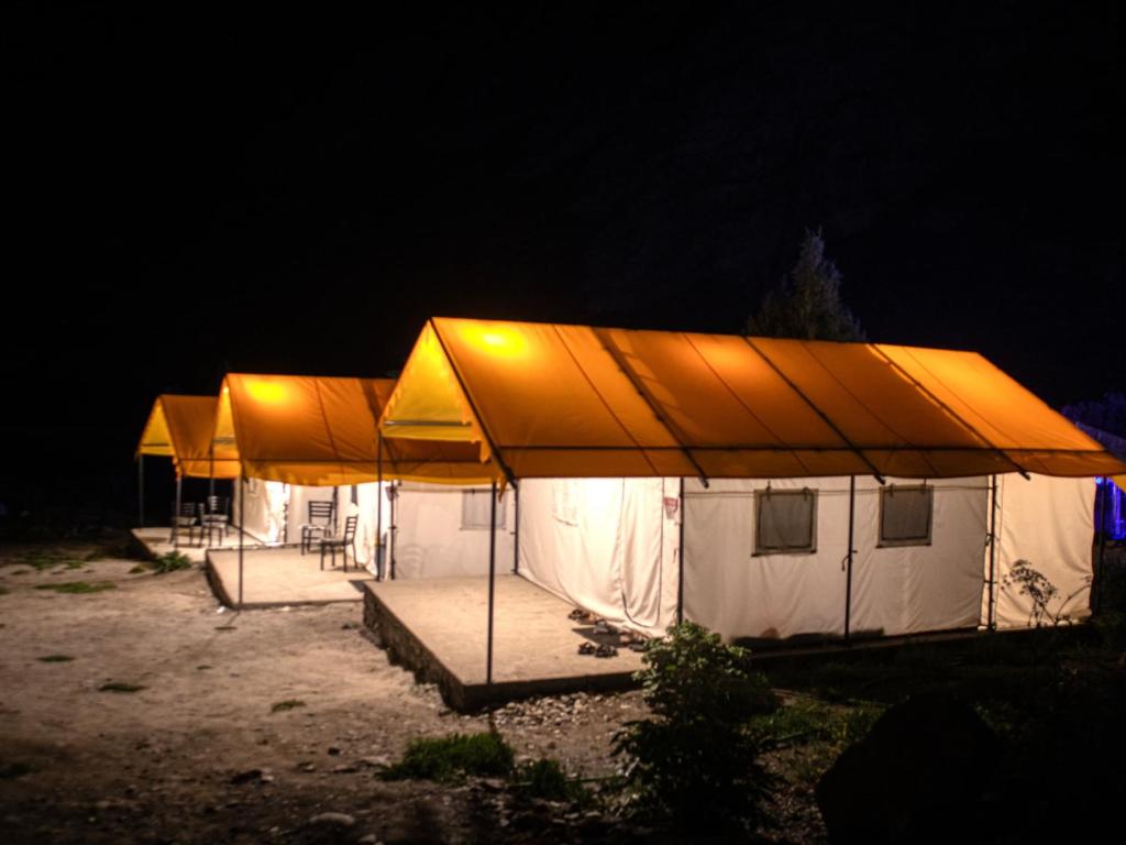 a row of tents in a field at night at GoingZero Luxury Camps Jispa in Jispa