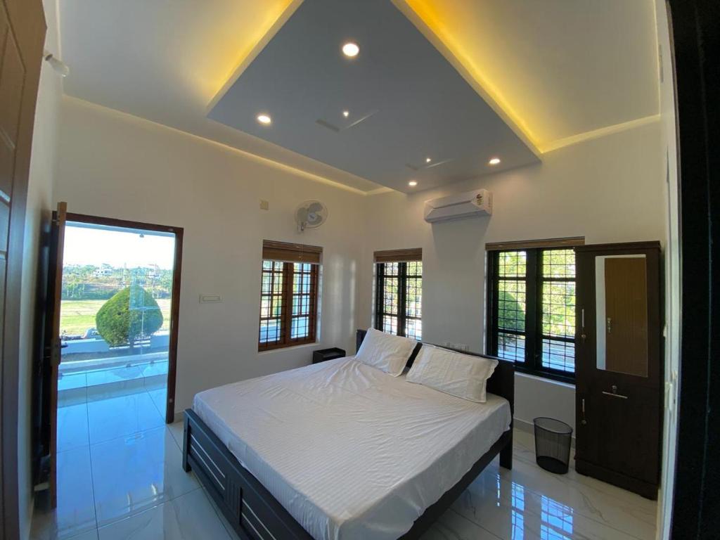a bedroom with a bed and a large window at Pappa's Holidays in Sultan Bathery