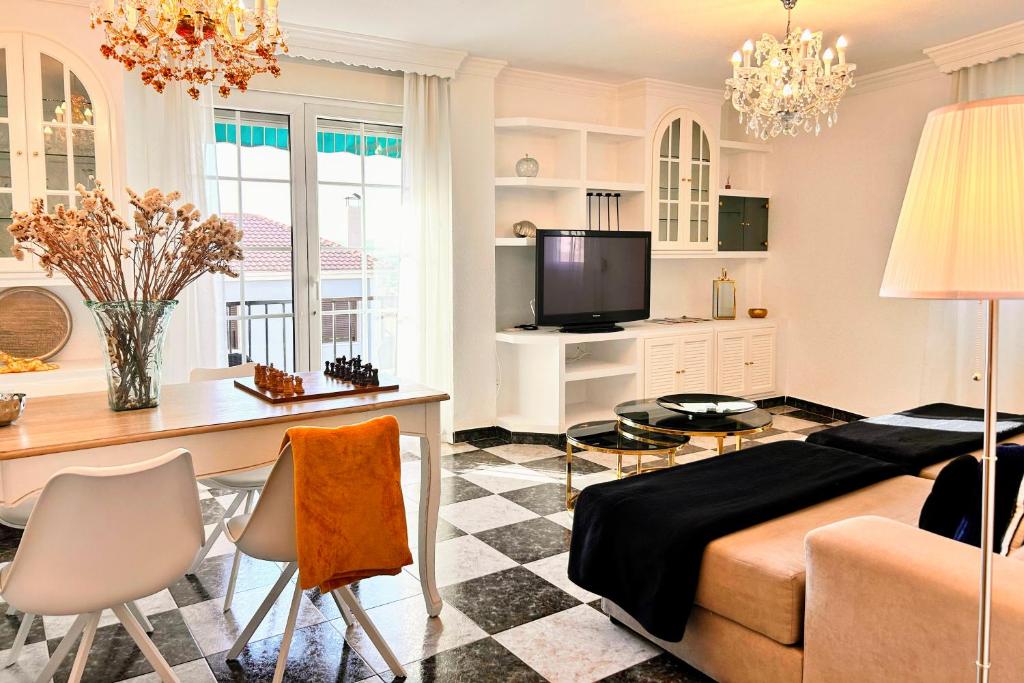 a living room with a bed and a table with chairs at Íberos Royal in La Zubia