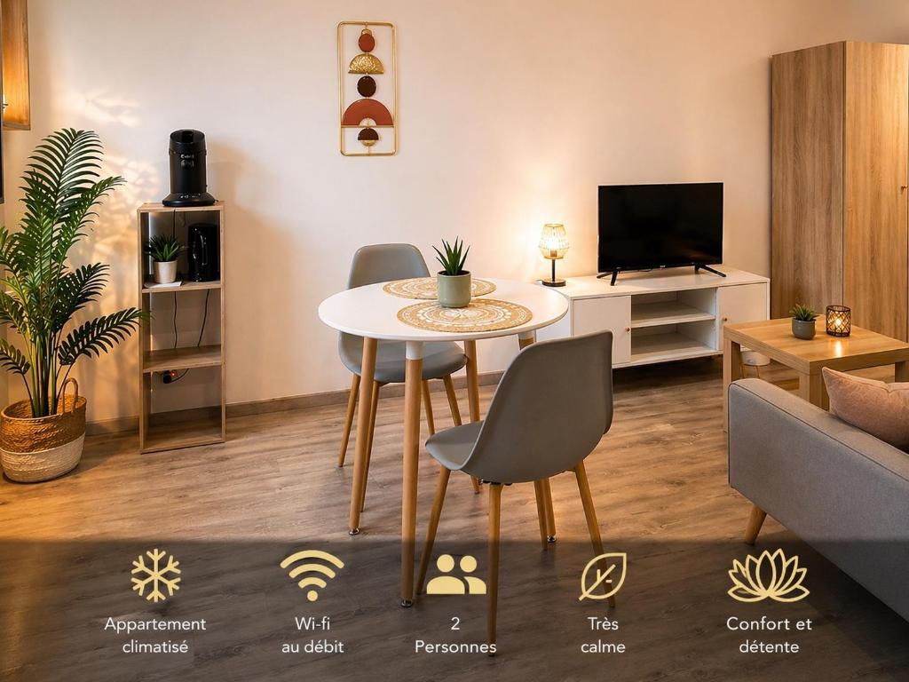 a living room with a table and chairs and a tv at Appartement loft terracotta in Manosque