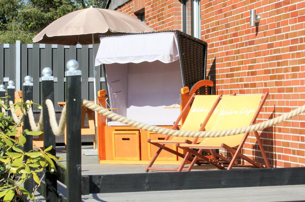 a chair and an umbrella next to an umbrella at Ferienhaus Weideblick in Hymendorf