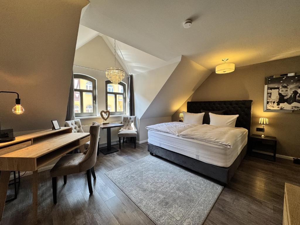 a bedroom with a bed and a desk and a table at Pension Burkhardt in Meißen