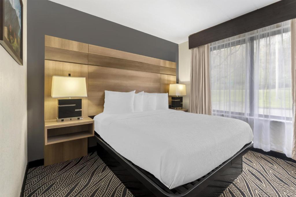 a hotel room with a large bed and a window at Best Western Braddock Inn in La Vale