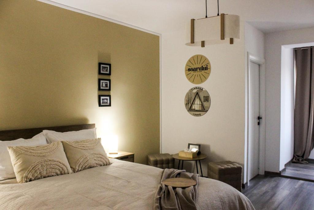 a bedroom with a bed and a clock on the wall at Soarelui Cozy Studio in Braşov