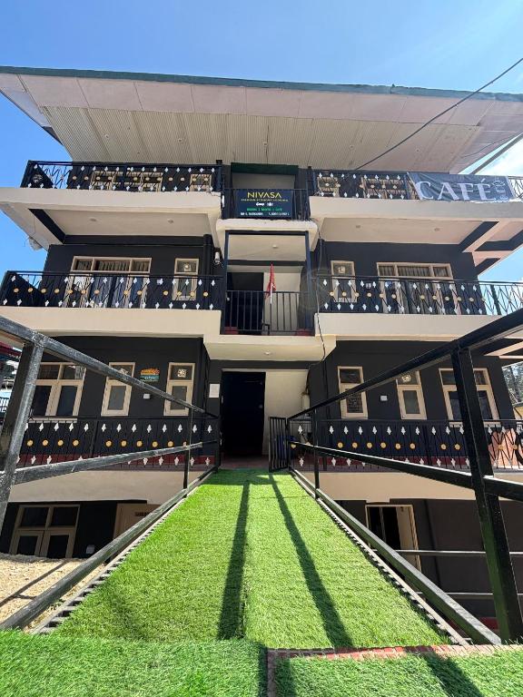 an apartment building with a staircase leading up to a balcony at Hotel Nivasa, Narkanda in Nārkanda