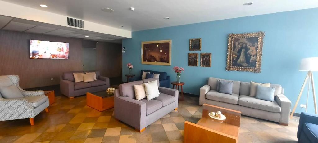 a living room with blue walls and couches at San Agustin Exclusive in Lima