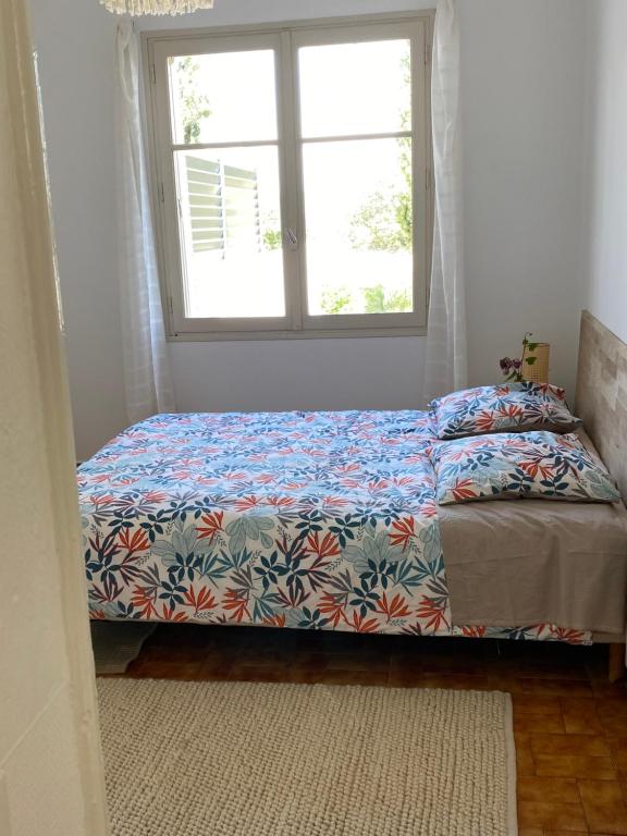a bed in a room with a window at Le Chêne in Villeneuve