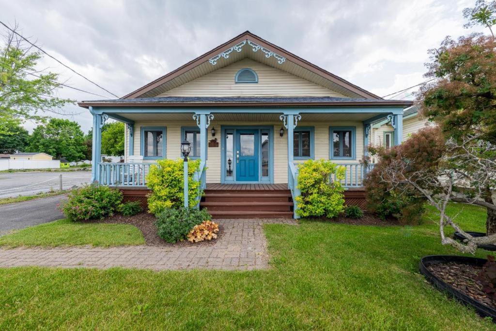 a house with a blue door and a yard at Le Repere du Lac - Lake View Access & Spa in Venise-en-Québec