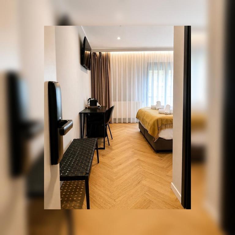 a hotel room with a bed and a television at NOVO Studio Hotel in Râmnicu Vâlcea
