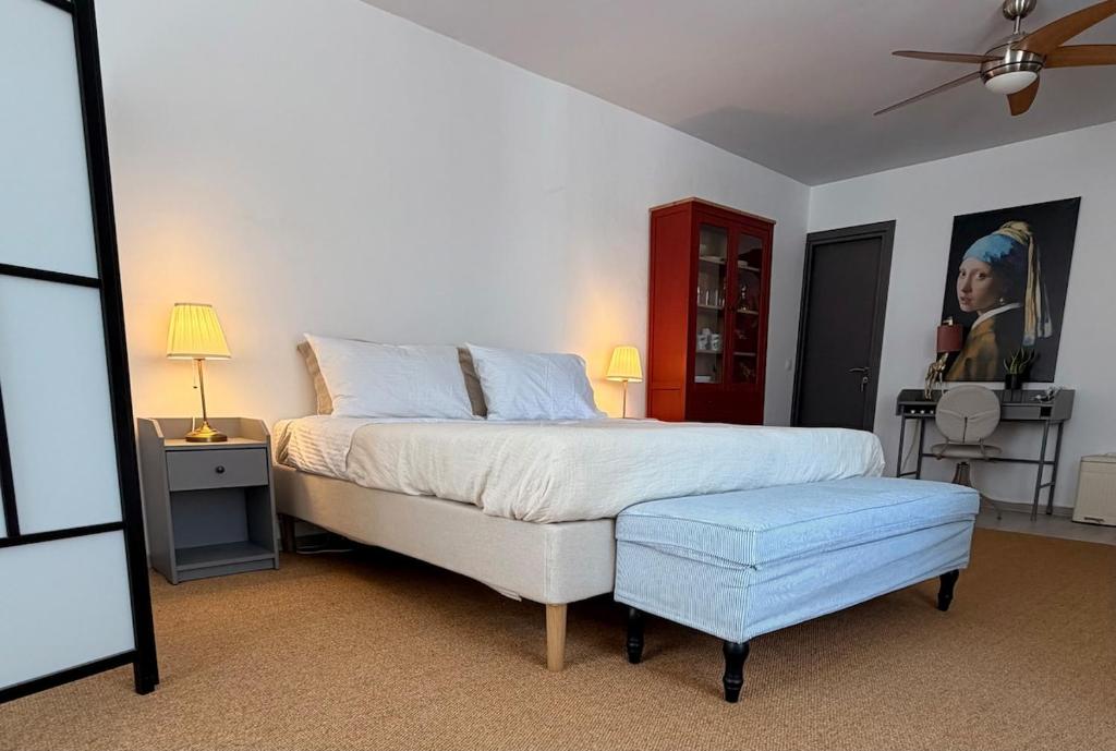 a bedroom with a large bed and a blue stool at ΑtoZ studio in Hydra in Hydra