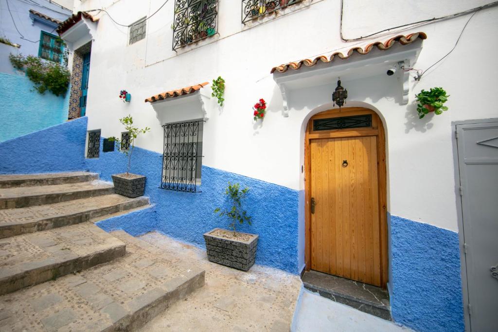a blue and white building with a wooden door at A&C Blue Haven in Chefchaouen