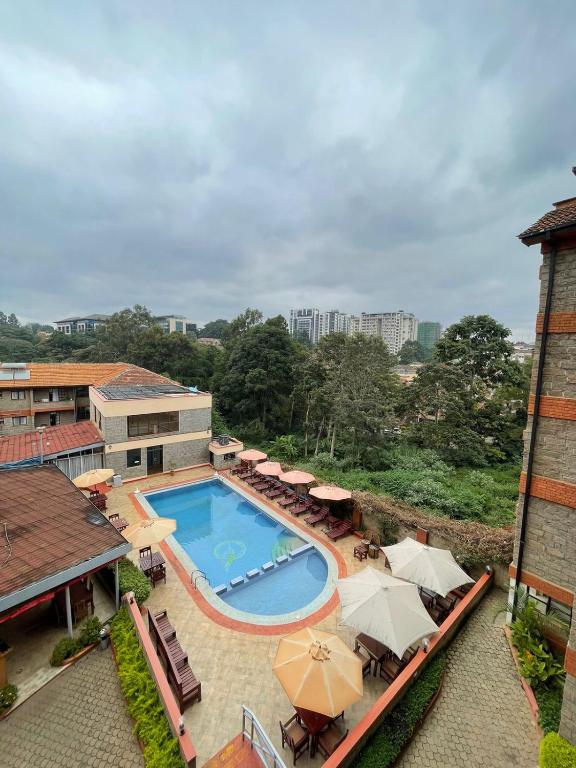 an overhead view of a swimming pool with chairs and umbrellas at The Olive Homes in Nairobi