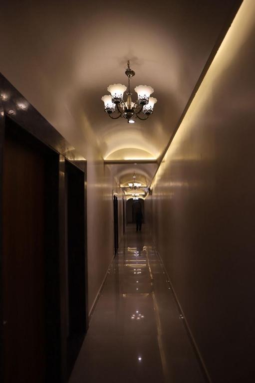 a hallway in a building with a chandelier at The Mukhiya Palace in Govardhan