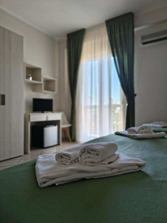 a hotel room with towels on a bed with a window at Il Quadrifoglio in Frascineto