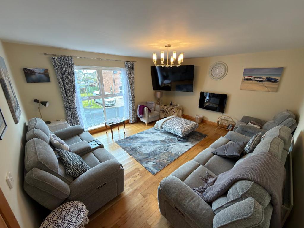 a living room with two couches and a tv at 10 Mill Square in Portstewart