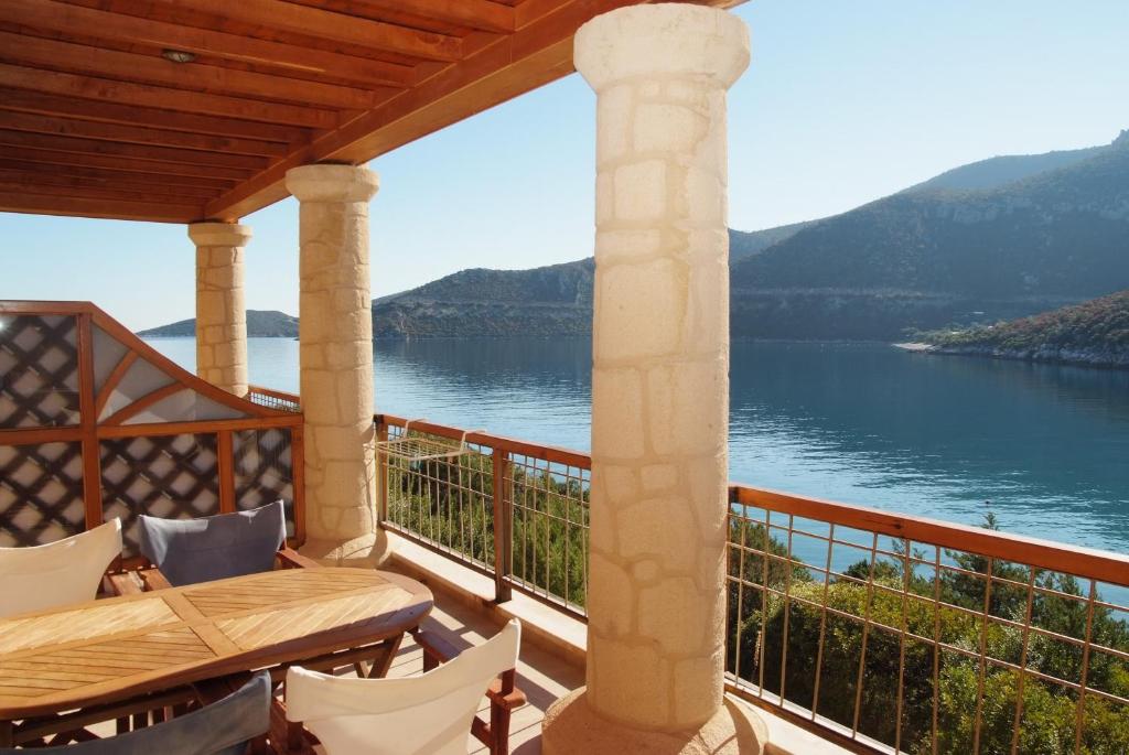 a balcony with a view of the water at Secret Arcadia Bay - Maisonette Breathtaking sea & mountain view-Just on the beach in Áyios Andréas Arkadias