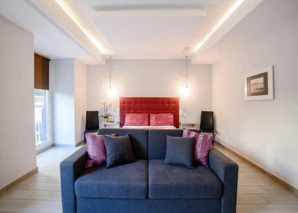 a living room with a blue couch in front of a bed at Riviera Luxury Suites in Naples