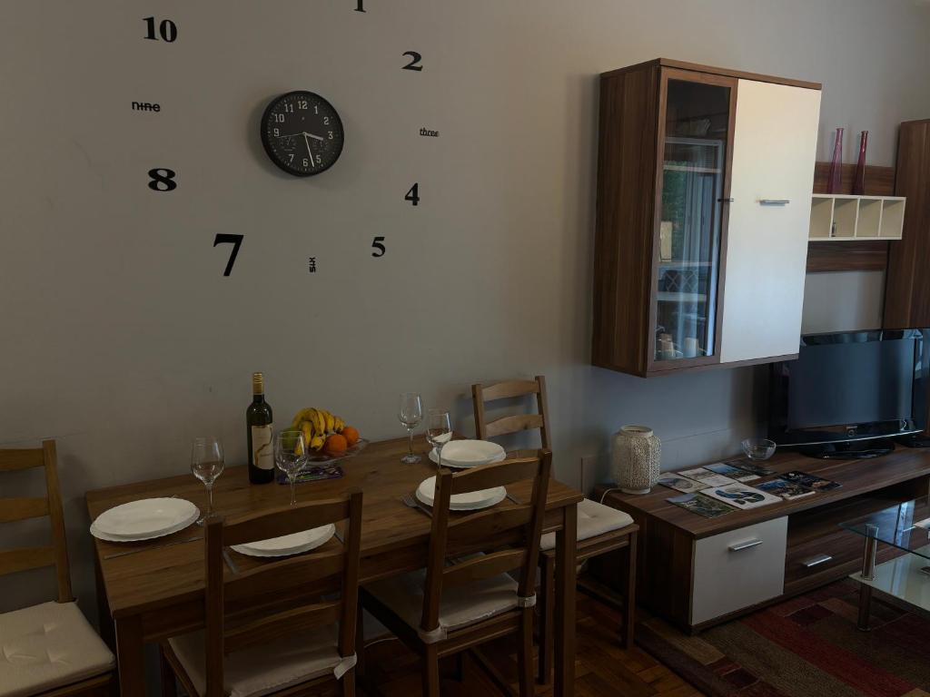 a dining room with a table and a clock on the wall at Apartment T&T in Lovran