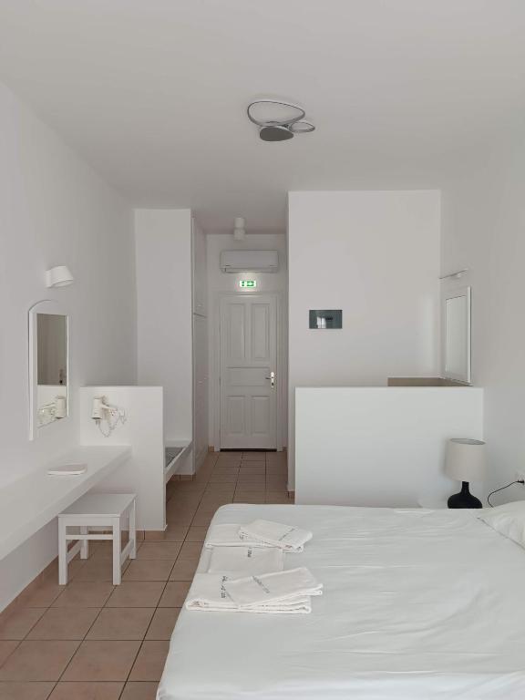 a white room with a bed and a sink at Paraporti in Chora Folegandros