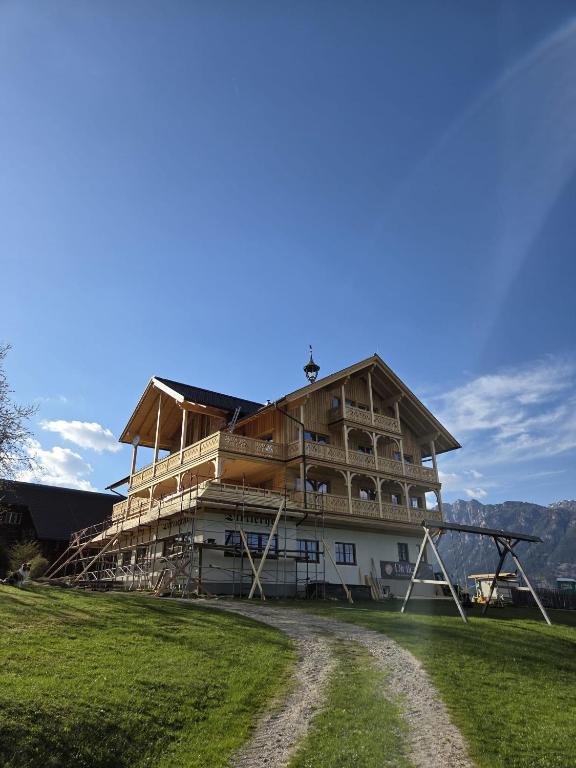 a building being constructed on top of a field at Dirtlergut in Haus im Ennstal