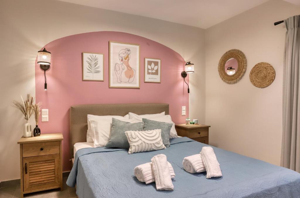 a bedroom with a blue bed with pink walls at Eftychia's Cozy Apartment in Sitia