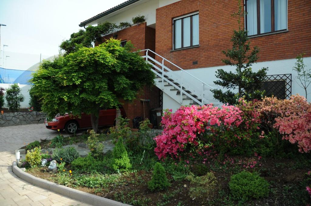 a garden in front of a house with flowers at B&B Gatto Rosso in Sandigliano