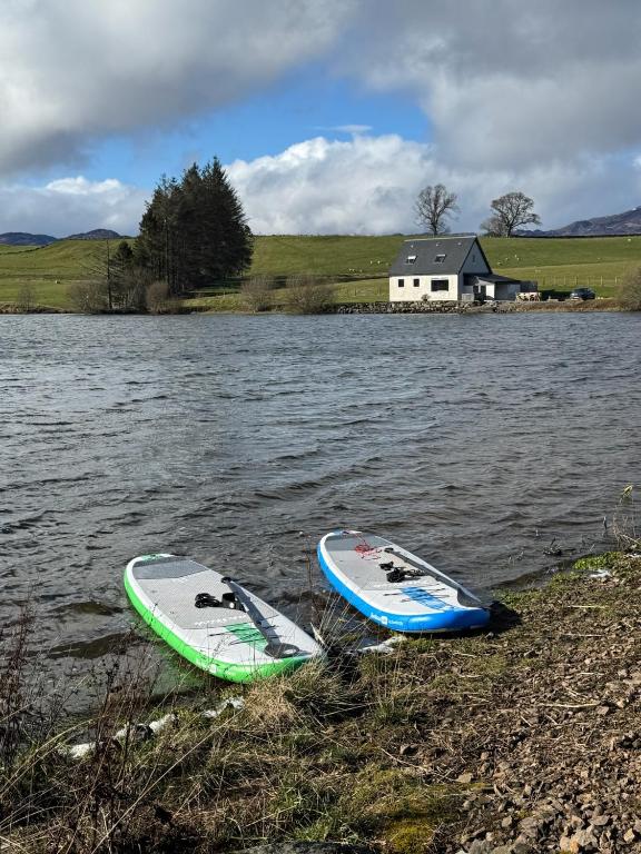 two surfboards sitting on the shore of a body of water at Wallace Lodge in Crieff