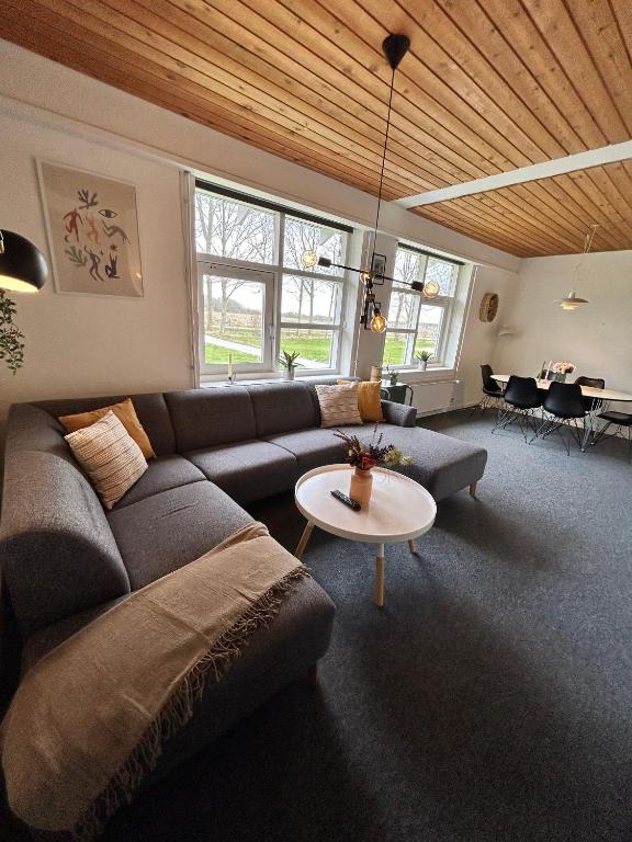 a living room with a couch and a table at Overnatning med plads til mange in Holstebro
