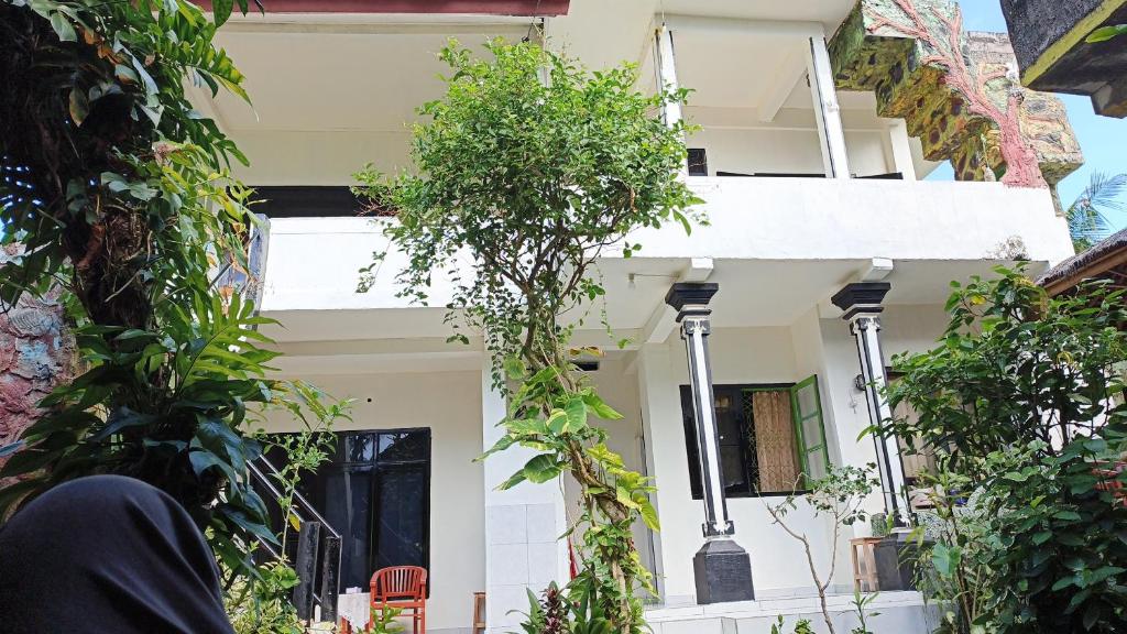 a white house with plants in front of it at Pondok Diana 3 in Jasri