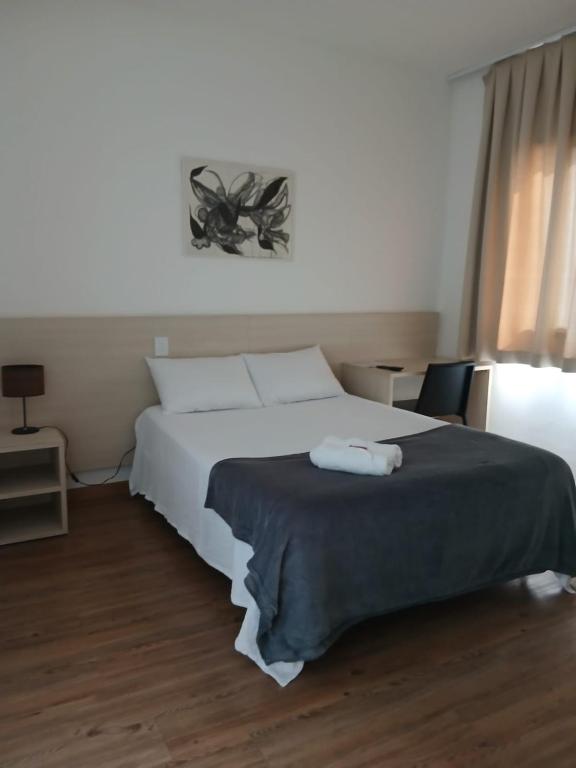 a bedroom with a bed with two towels on it at Flat Lagoa Santa in Lagoa Santa