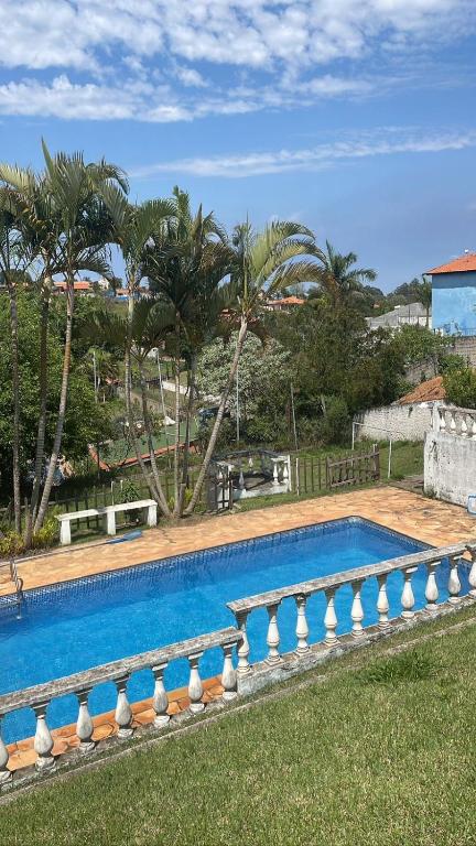 a swimming pool in a yard with palm trees at Farm km 68 Castelo Branco in Mairinque