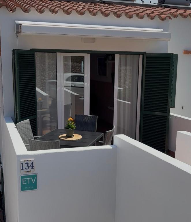 a balcony of a house with a table and chairs at Garbí & Xaloc apartamentos in Cala Galdana
