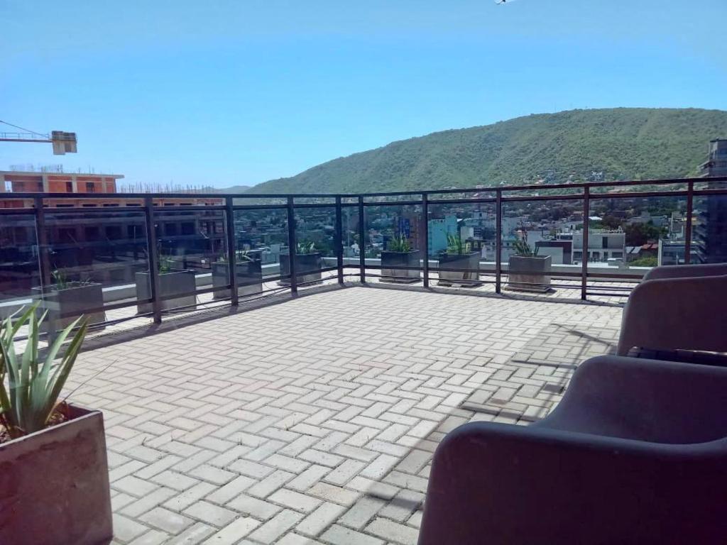 a balcony with chairs and a view of a mountain at Edificio Leonardo Premium Centro Las Heras in Villa Carlos Paz